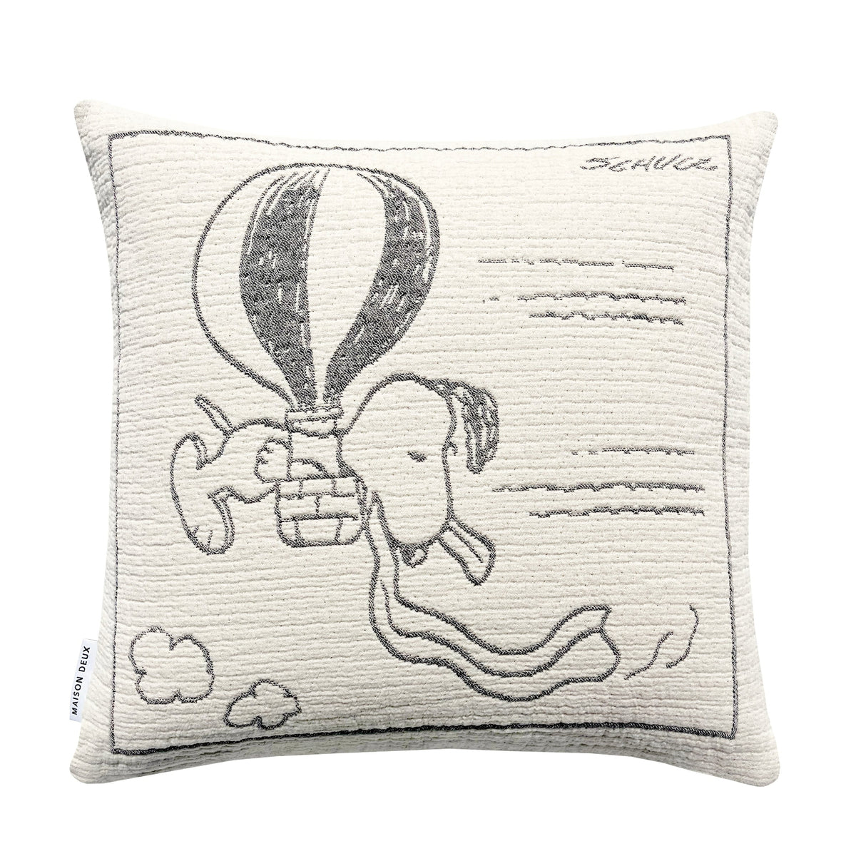 Square white cotton Maison Deux Peanuts Cushion featuring a black line drawing of Snoopy flying in a hot air balloon, with the signature Schulz in the upper right corner.