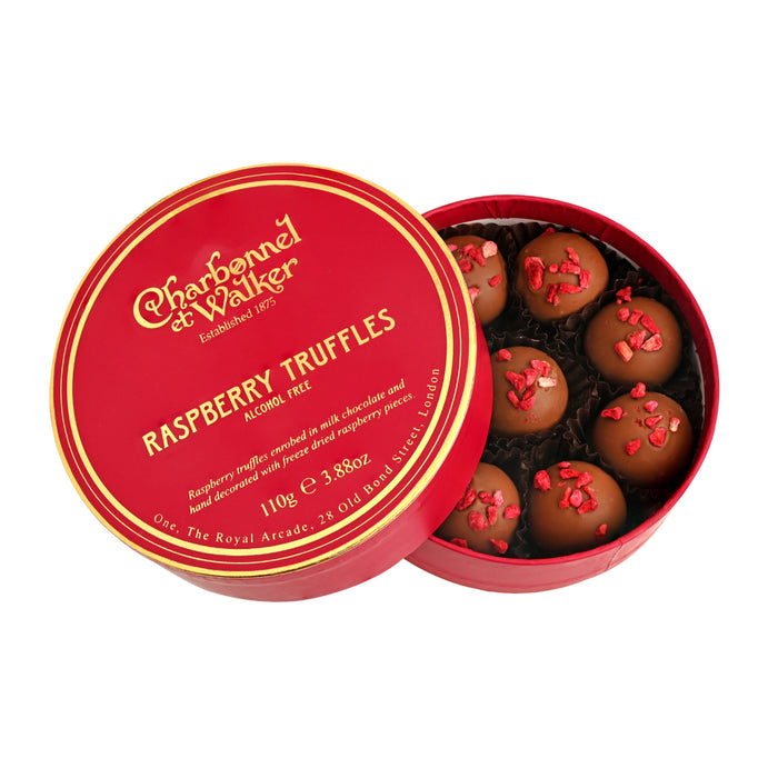 Round red gift box filled with Charbonnel & Walker Raspberry Truffles, 110g topped with dried raspberry pieces, with the lid resting beside it displaying product information.