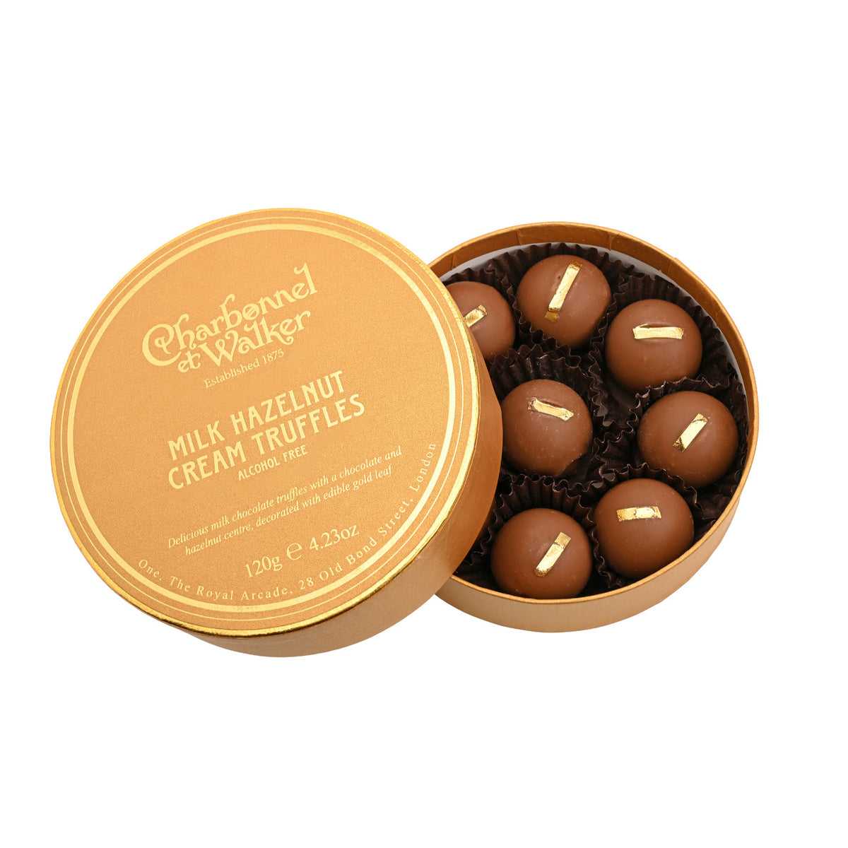 Round gold box with its lid removed, containing seven Hazelnut Cream Milk Chocolate Truffles topped with edible gold leaf.