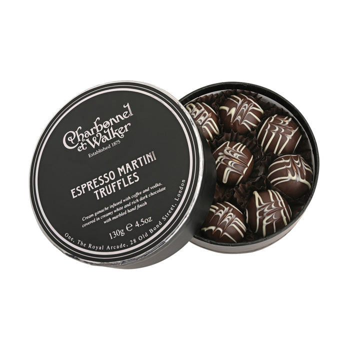 A round black Charbonnel & Walker Espresso Martini Truffles 130g gift box containing dark chocolate truffles with white drizzled patterns, with the product name and information printed on the open lid.