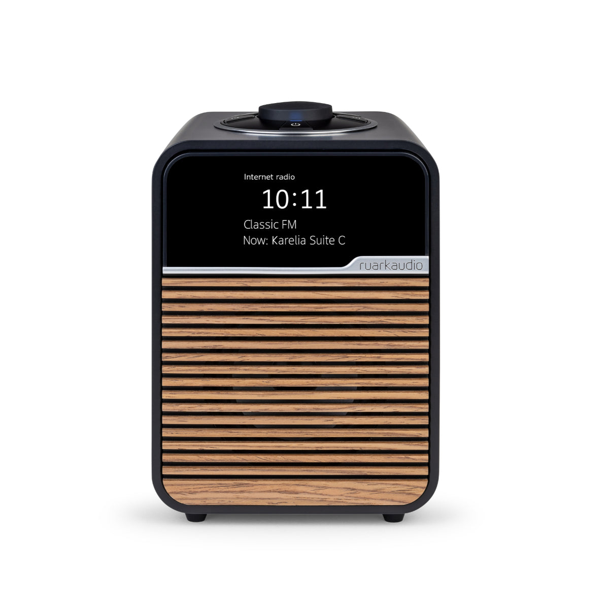 The Ruark R1S Smart Radio by Ruark features a black top, rotary knob, wooden slatted front with ruarkaudio branding, Wi-Fi connectivity, and a digital display showing 10:11, Classic FM, Now: Karelia Suite C.