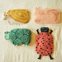 Four plush toys shaped like a snail, cat, turtle, and ladybug are arranged on a light fabric background. Each toy features its own unique, colorful pattern and friendly, simple facial features—crafted with the same care and attention to detail as Donna Wilson’s Ginge Cat Hot Water Bottle.