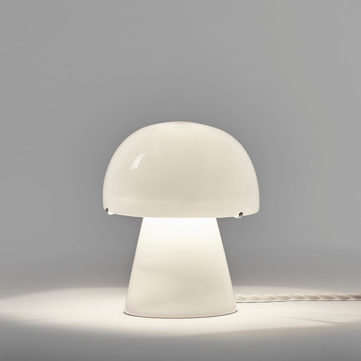 Serax Joe n°1 Table Lamp made of bone china, shaped like a mushroom with a glowing dome shade.