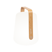 The Fermob Balad2 Outdoor Light, Bamboo, H38 is a modern, minimalist lamp with a rounded base and curved bamboo handle—perfect as a portable light for your garden or patio.