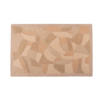 A rectangular, hand-tufted Bojagi Rug by Ligne Roset with a geometric, mosaic-like pattern in shades of tan and brown.