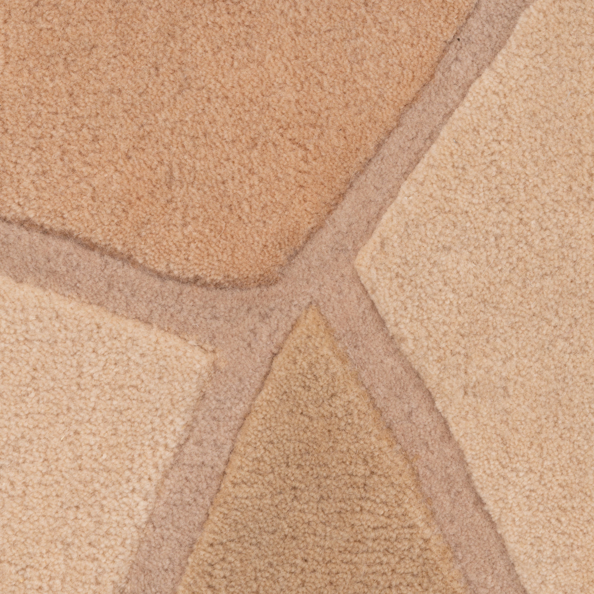 A close-up of a Ligne Roset Bojagi rug, a sculptural hand-tufted design with a stone-like pattern featuring various shades of tan and brown separated by recessed lines.
