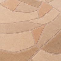 A Ligne Roset Bojagi area rug featuring a hand-tufted tan and beige carved, abstract geometric pattern of organic, leaf-like shapes.