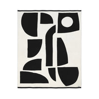 Sophie Home Bruten throw in off-white cotton featuring a large-scale abstract design of black geometric shapes and a single circle.