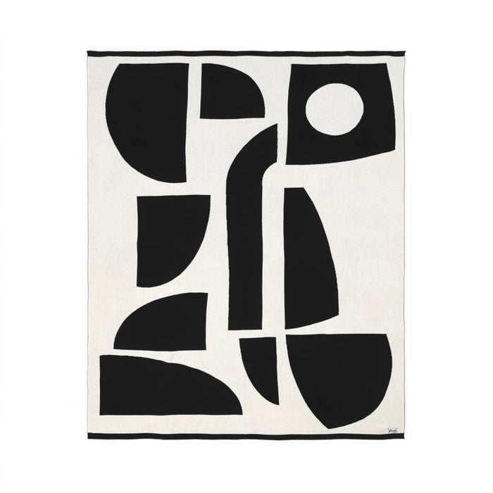 Sophie Home Bruten throw in off-white cotton featuring a large-scale abstract design of black geometric shapes and a single circle.