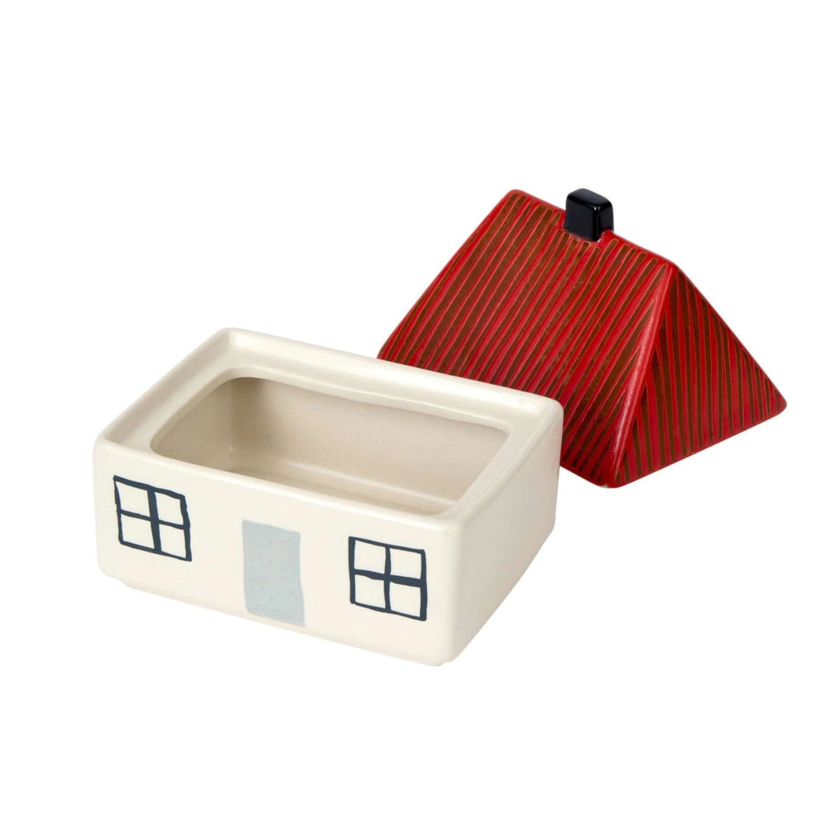 Charming and whimsical, the Donna Wilson House Butter Dish is a sturdy stoneware container in the shape of a small house. Designed by Donna Wilson, it features a red, ridged roof that serves as the removable lid and simple painted windows and door details on its white rectangular base.