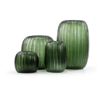 Four green, ribbed Guaxs Erongo Vases in assorted heights and shapes are arranged on a white background, highlighting the artistry of mouthblown glass.