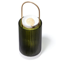 La Promeneuse by Trudon, featuring a fluted green glass lantern with a white base, a metal handle, and a scented wax cameo resting on a white ceramic dish.