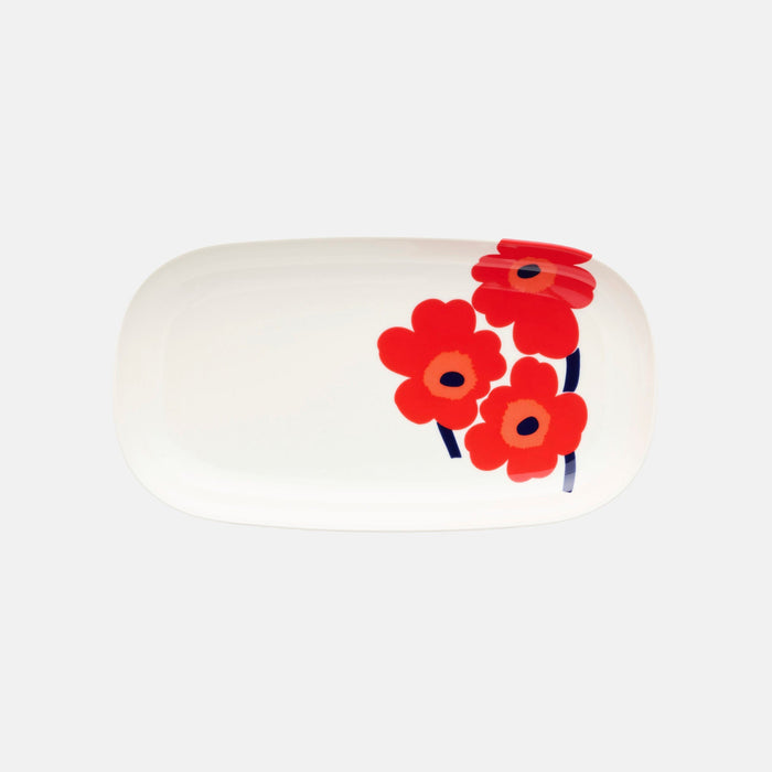 The Marimekko Oiva / Unikko Serving Dish is a white oval dish featuring a bold floral design with three red Unikko poppy flowers and dark stems on one side, set against a simple light background.