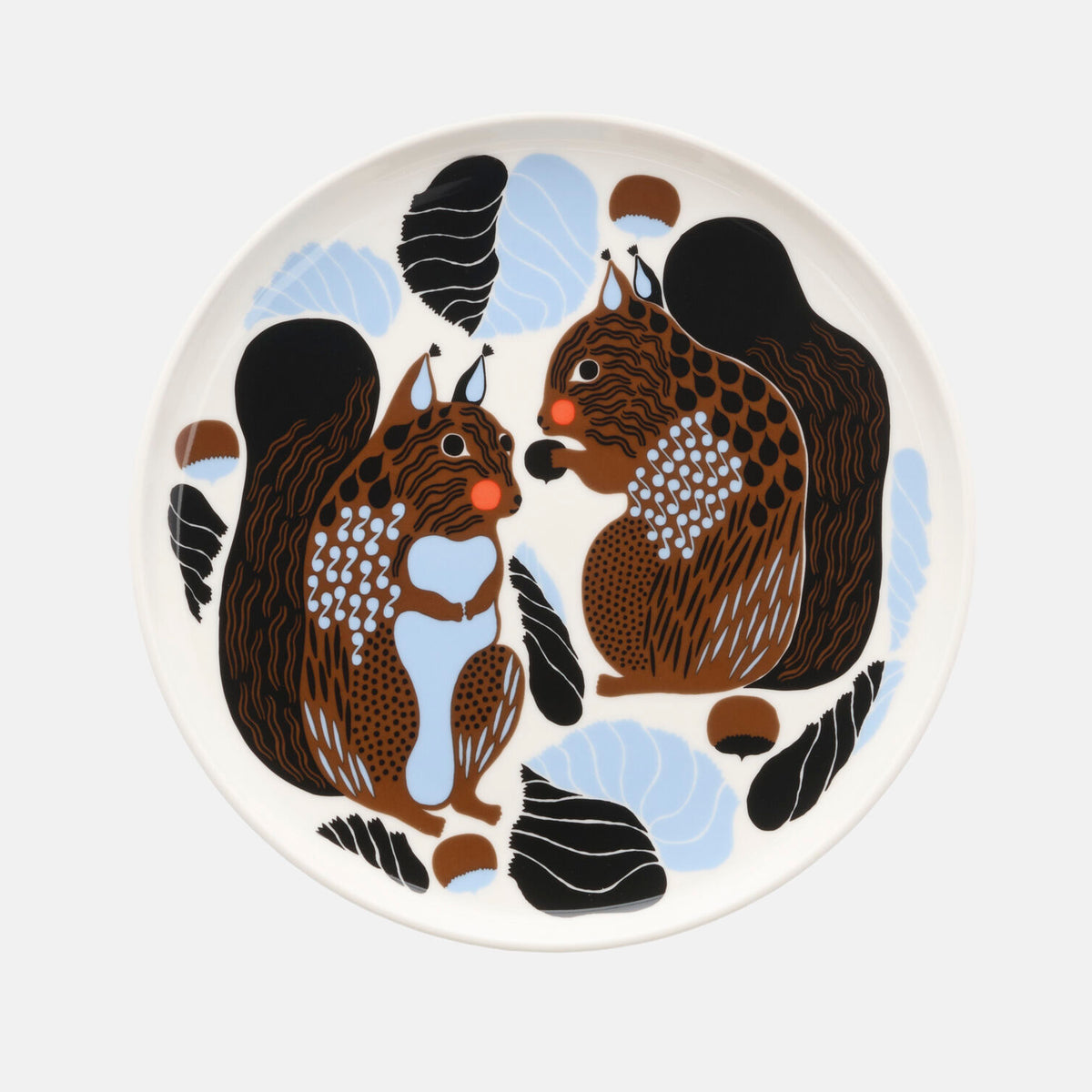 The Marimekko Oiva / Kurre Plate 20cm showcases two stylized brown squirrels facing each other, surrounded by abstract black, blue, and brown leaves and acorns on a white background—a charming forest-inspired design perfect for the Christmas Edition 2026.