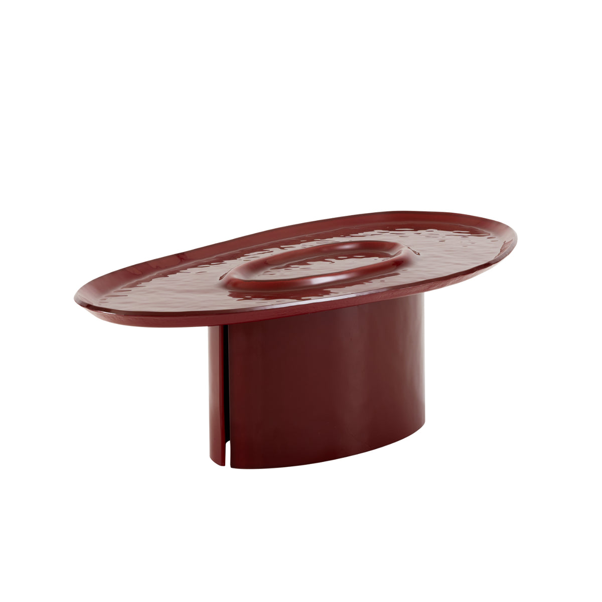 Low, oval-shaped red hammered lacquered glass Oasi Low Table by Ligne Roset, featuring a textured, basin-like tabletop supported by a single cylindrical base.
