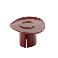 A low, dark red Ligne Roset Oasi Low Table with a wide, organic-shaped top featuring a recessed center and a cylindrical base with a vertical slit.