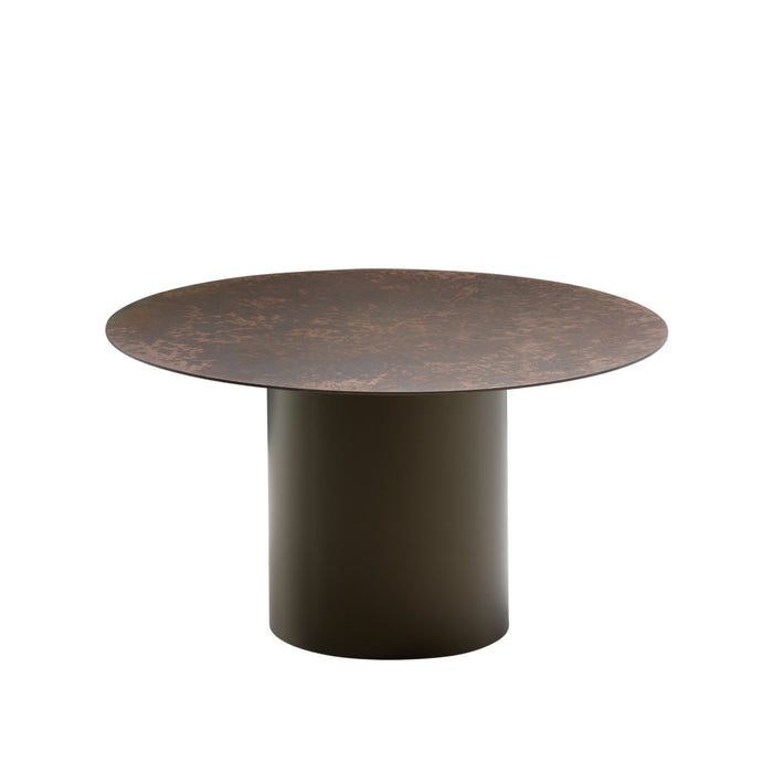 The Oxydation Coffee Table by Ligne Roset features a wide, flat, brown textured top and a solid cylindrical dark brown base, set against a plain white background. Drawing inspiration from Kateryna Sokolova’s distinctive style, this piece showcases the artistry of oxidised metal tables found in her renowned Oxydation tables collection.