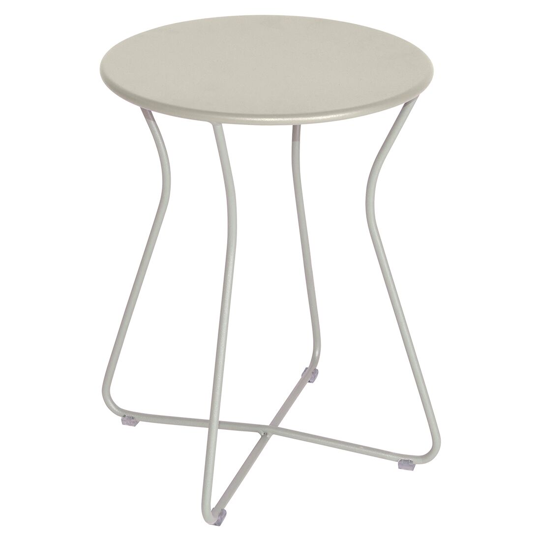 The Fermob Cocotte Side Table is a small, round outdoor table in light gray, made of weatherproof steel with a smooth top and four slender, curved legs that cross at the base for stability.
