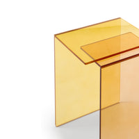 A close-up of the Patchs Occasional Table by Ligne Roset, featuring modern, translucent amber acrylic with clean, minimalist lines and transparent yellow tones—perfect for a contemporary interior—set against a white background.