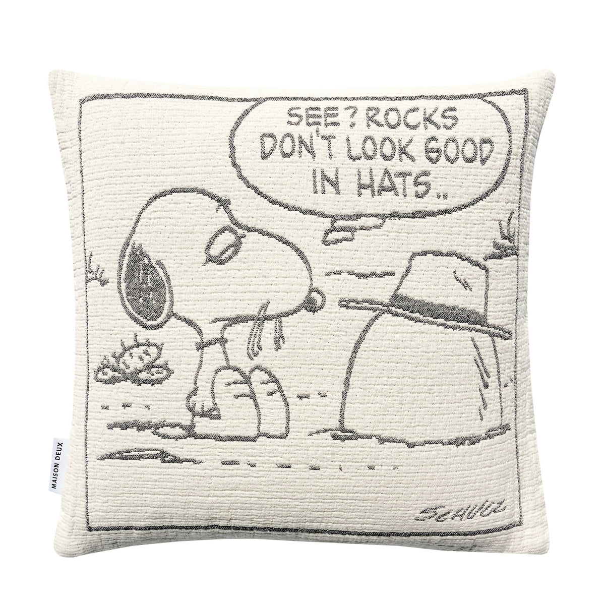 Maison Deux Peanuts Cushion featuring a line drawing of Snoopy looking at a rock wearing a hat, with a speech bubble that reads, SEE? ROCKS DONT LOOK GOOD IN HATS..
