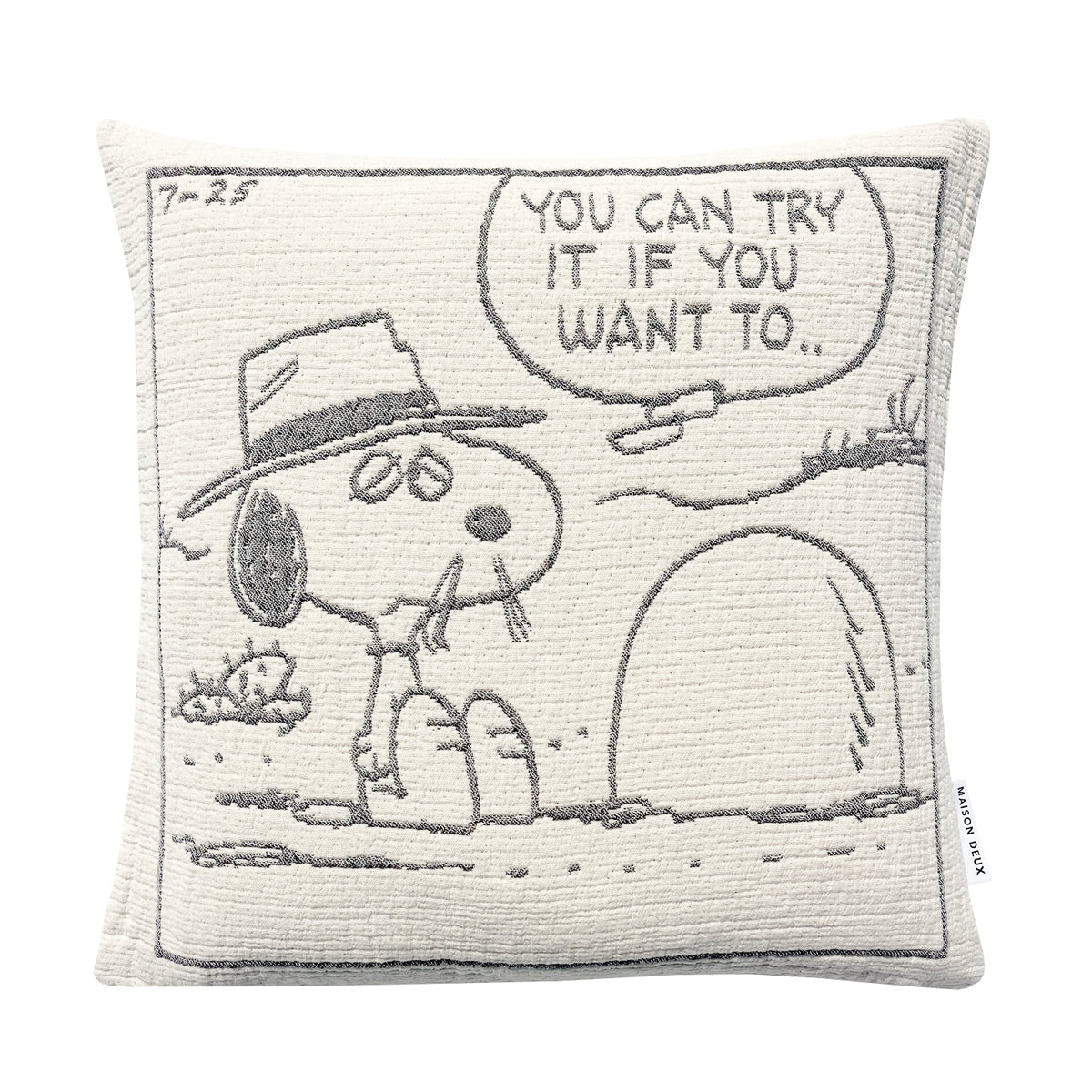 Square Maison Deux Peanuts Cushion featuring a woven comic strip panel of Snoopy wearing a hat and sitting by a hole, with a speech bubble that reads, YOU CAN TRY IT IF YOU WANT TO.