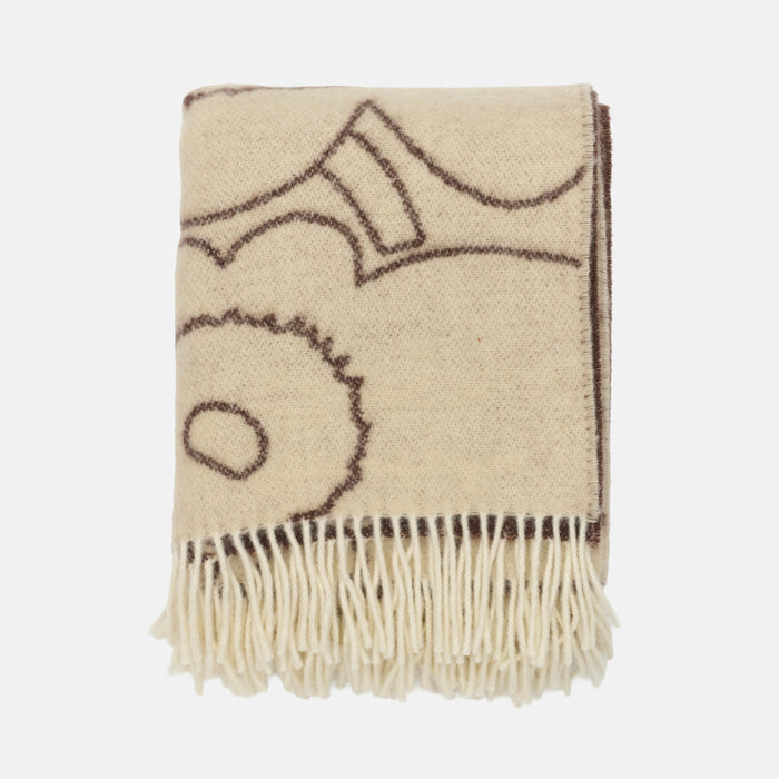 The Piirto Unikko Blanket by Marimekko is a folded beige throw featuring brown abstract line drawings and cream-colored fringe along the edge, crafted from 100% wool and displayed against a white background.