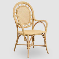 The Romantica Wicker Chair by Sika Design features a natural rattan frame, curved armrests, rounded backrest with lattice detailing, woven seat, and four sturdy legs.