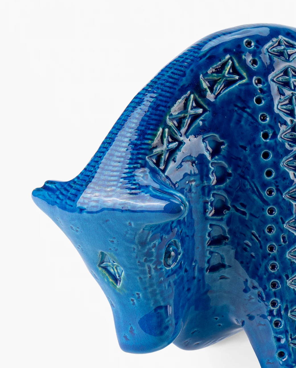 A close-up of Bitossi's Bull Figure, a glossy blue ceramic sculpture in the Rimini Blu style with geometric patterns and raised textures, reminiscent of the brand’s iconic mid-century animal designs.