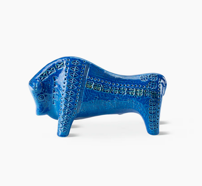 The Bitossi Bull Figure, inspired by Rimini Blu, showcases textured patterns and geometric designs in blue ceramic—a bold tribute to mid-century style, displayed on a white background.