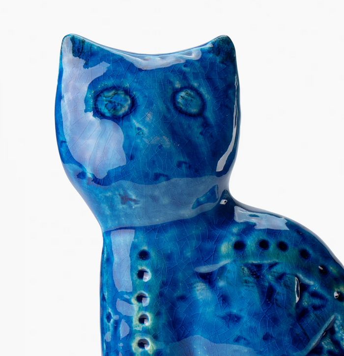 The Seated Cat Figure by Bitossi features a glossy ceramic finish in vibrant Rimini Blu, with crackled and textured details inspired by iconic mid-century design, showcased against a plain white background.