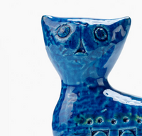 A close-up of the Bitossi Long Cat Figure highlights its blue ceramic, abstract features, and textured glaze—showcasing Rimini Blu influence and mid-century style—set against a white background.