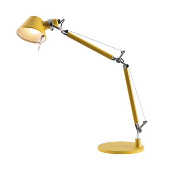 The Artemide Tolomeo Micro Desk Lamp is a modern yellow lamp with a round base and an adjustable, articulated arm, shown illuminated against a plain white background.