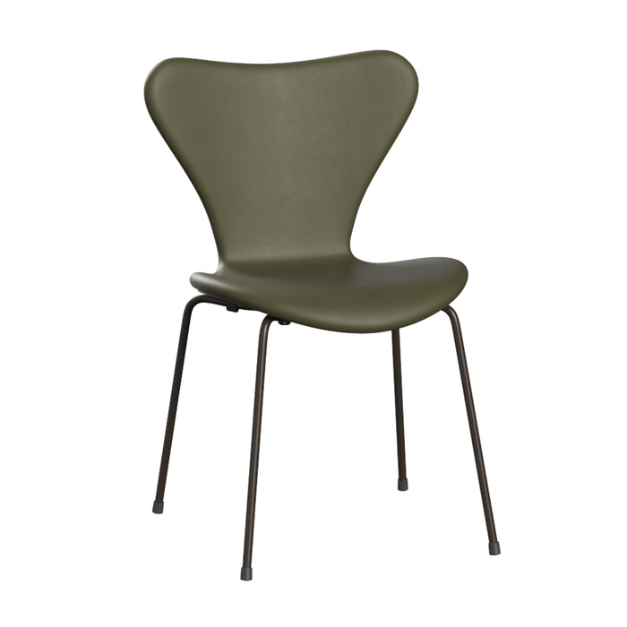 The Series 7 Chair, Essential Leather by Fritz Hansen is a contemporary reinterpretation of Arne Jacobsen’s timeless design, featuring a fully upholstered olive green curved seat and backrest for enhanced comfort, supported by four slender black metal legs.