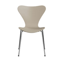 The Fritz Hansen Series 7 Chair in light beige features a modern, Danish-inspired design with a curved backrest and chrome metal legs, reminiscent of Arne Jacobsen’s iconic creation, photographed against a white background.