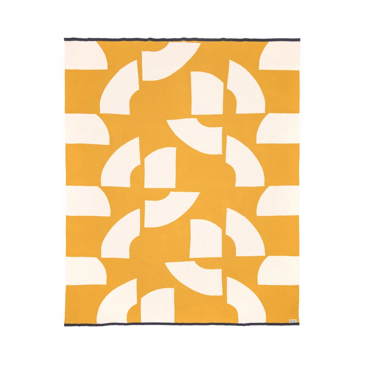 Sophie Home Deko throw blanket in mustard yellow featuring a repeating white geometric pattern of stylized arcs.