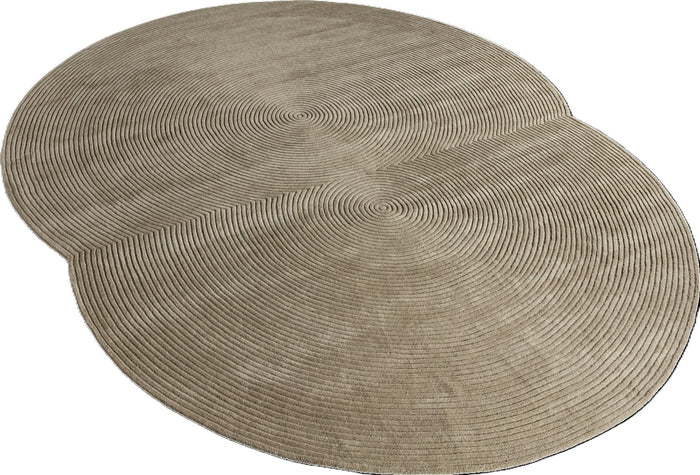 The Zen Rug Rounded by Bolia is a beige wool rug with two overlapping circles and concentric line patterns, offering a modern, Japanese-inspired geometric look in undyed wool.