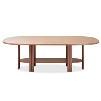 The Saba Anam Dining Table is a modern, oval-shaped piece featuring a smooth light brown top, six cylindrical legs, a matching lower shelf for storage, and a cohesive brown finish throughout.