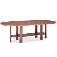 The Saba Anam Dining Table is a long, oval brown table with rounded edges, six thick cylindrical legs, and a matching shelf below. It offers a contemporary, minimalist design for modern dining spaces.