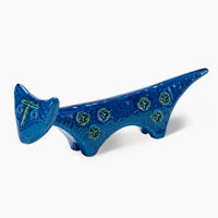 The Bitossi Cat Figure is a blue ceramic figurine featuring a long body, short legs, green circles along its side, and a glossy finish—an elegant tribute to Rimini Blu mid-century style.