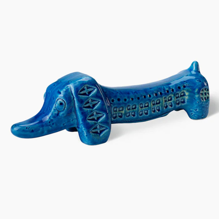 The Bitossi Dachshund Figure is a blue ceramic figurine featuring Rimini Blu patterns and mid-century style, inspired by Bitossi Ceramiche, shown on a plain white background.