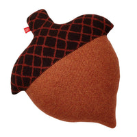 The Acorn Shaped Cushion by Donna Wilson is a decorative pillow crafted in Scotland from soft lambswool. Shaped like an acorn, it features a textured brown bottom, a darker brown top with a crisscross pattern, and is finished with a small red tag on one side.
