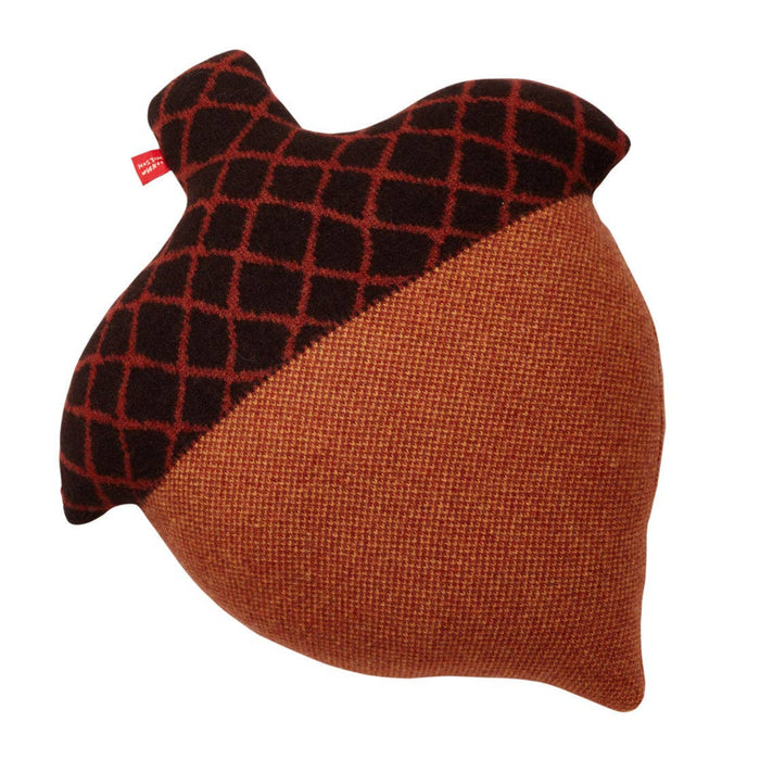 The Acorn Shaped Cushion by Donna Wilson is a decorative pillow crafted in Scotland from soft lambswool. Shaped like an acorn, it features a textured brown bottom, a darker brown top with a crisscross pattern, and is finished with a small red tag on one side.