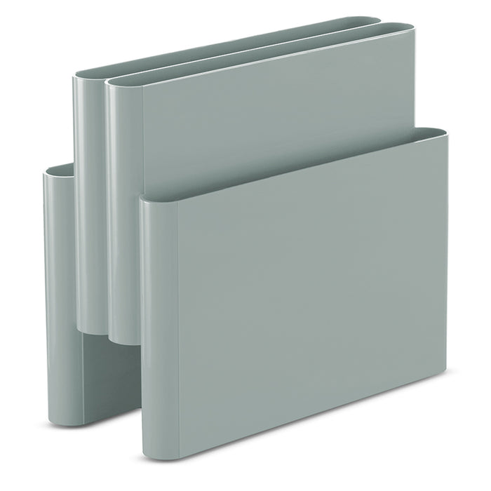 The Kartell Magazine Rack features a modern, minimalist design inspired by mid-century Italy, with a light gray finish, two compartments at different heights, and rounded edges. It stands upright on a white background.