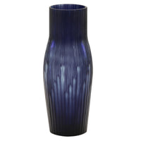 The Purple Rain Vase by Ligne Roset is a tall, cylindrical mouth-blown glass vase in deep blue with a narrow neck and vertical textured ridges, offering a striking contemporary decorative accent.