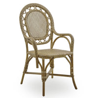 The Romantica Wicker Chair by Sika Design features a rounded backrest, armrests, woven seat, and decorative open weaving in natural light brown—perfect handmade rattan furniture for any space.