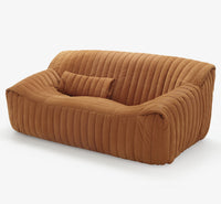The Sandra Small Sofa, Vidar by Ligne Roset features modern brown velvet upholstery, vertical quilting, rounded edges, and a matching pillow, shown on a plain white background.