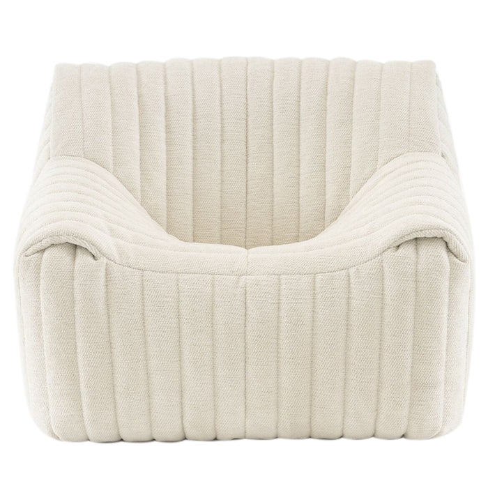 The Sandra Armchair, Vidar by Ligne Roset features a modern square design in cream with ribbed upholstery and deep cushioning, offering luxury comfort and a chic retro lounge vibe.