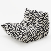 A modern Togo Fireside Chair, Tablu by Ligne Roset is displayed against a plain white background, featuring a plush, ruched design and a striking black-and-white zebra print pattern. This iconic piece embodies the essence of modular seating with its inviting form and contemporary flair.
