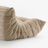 Phlox fabric Togo very large sofa by Ligne Roset, featuring a beige, corduroy-like tufted design with a low seat and no visible legs, reminiscent of Michel Ducaroy’s iconic style, set against a plain white background.