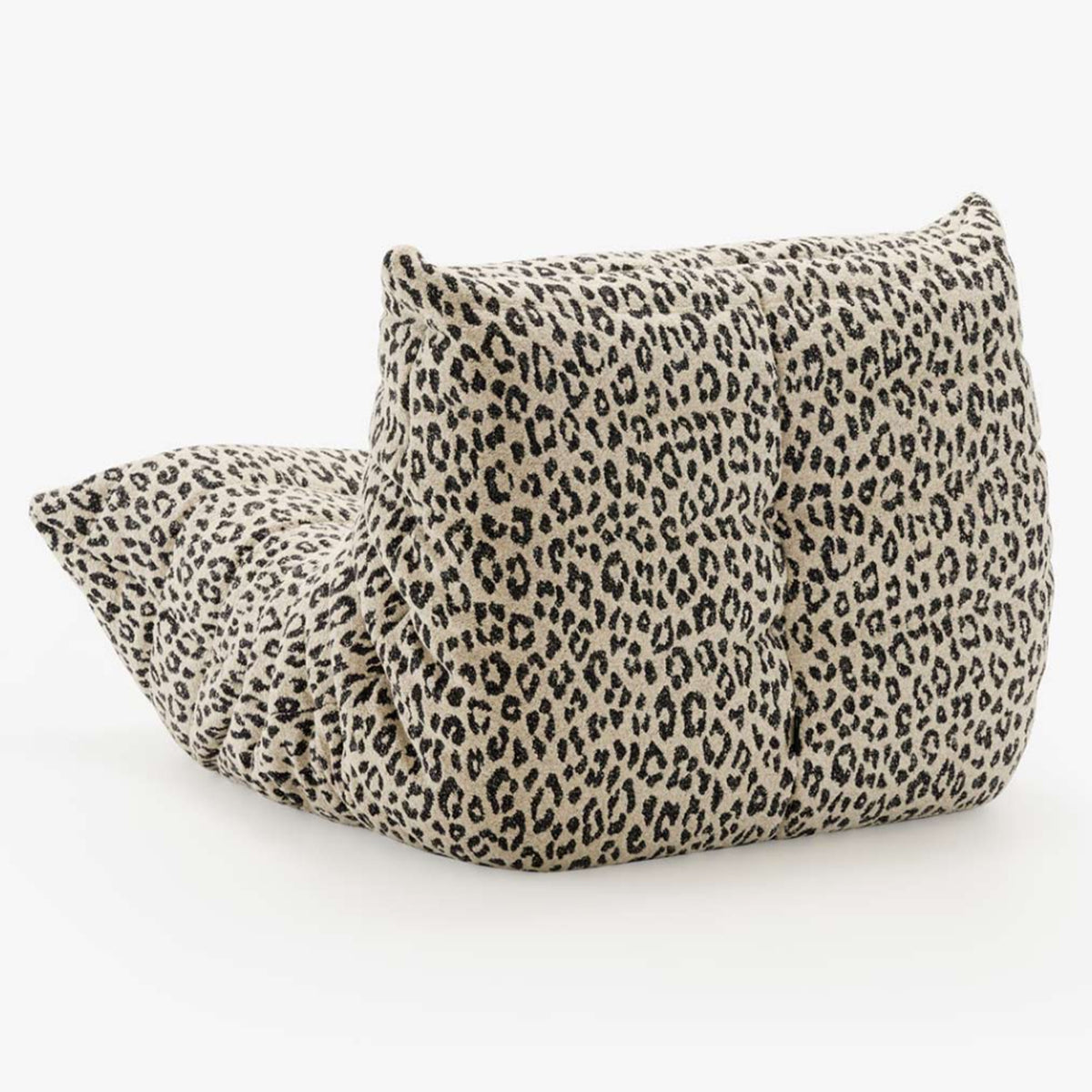 The Togo Fireside Chair, Tablu by Ligne Roset is a soft, low lounge chair featuring a leopard print fabric cover. Reminiscent of the iconic Togo design, it boasts a plush, tufted appearance and sits directly on the floor without visible legs or frame, embodying the essence of relaxed modular seating.